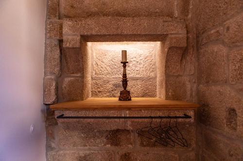 a candle on a shelf in a stone wall at Quinta de São Francisco Houses in Viseu