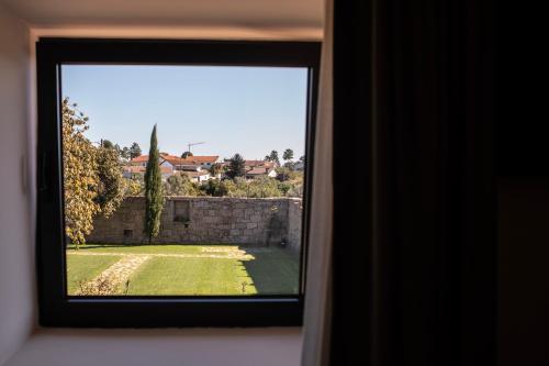a window with a view of a yard at Quinta de São Francisco Houses in Viseu