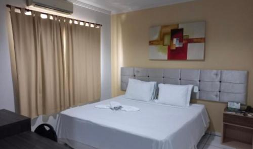 um quarto com uma grande cama branca num quarto em Barrudada Palace Hotel-Boa Vista em Boa Vista