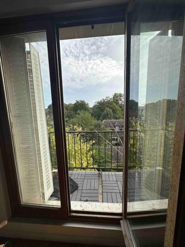 een raam in een kamer met uitzicht op een balkon bij Superbe appartement proche Paris 30 min RER in Saint-Maur-des-Fossés