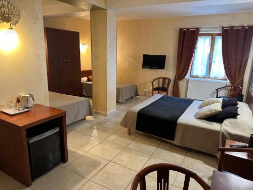 a hotel room with a bed and a tv at Hôtel Bon Encontre in Sarlat-la-Canéda