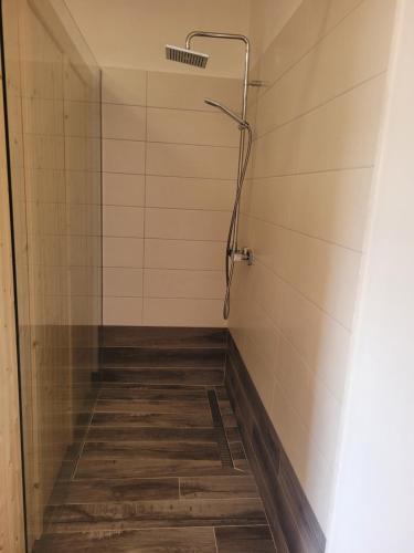 a shower in a bathroom with a wooden floor at Chata Kvilda in Kvilda