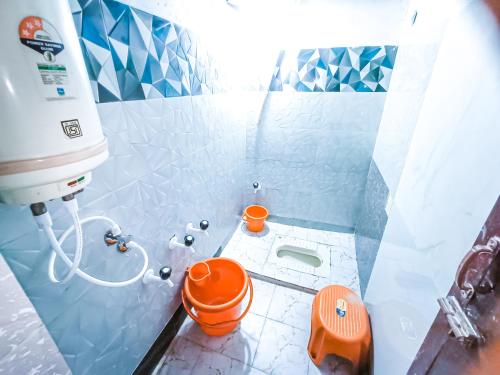 een badkamer met een oranje toilet en een wastafel bij Sahara Family Homestay in Mysore