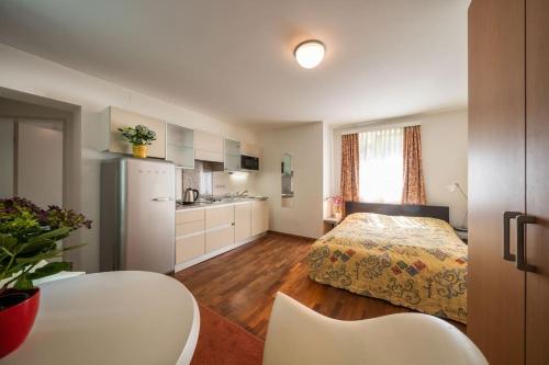 a small bedroom with a bed and a kitchen at Schlossquadrat Apartement 14 A in Vienna