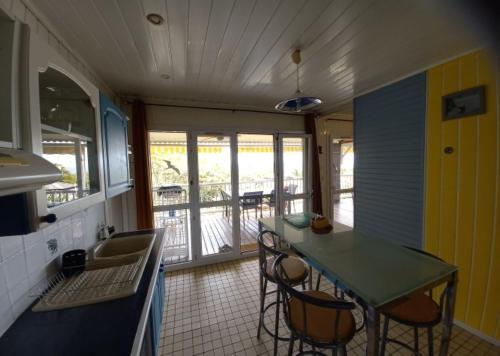 a kitchen with a table and chairs and a sink at Le Frégate ,belle vue mer , 150M de la plage, SPA privé in Bouillante