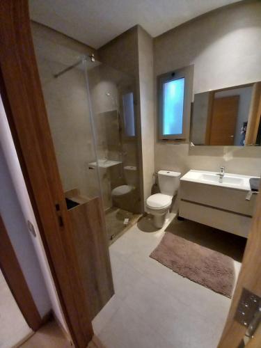 uma casa de banho com um WC, um lavatório e um chuveiro em Prestigia appt rez de jardin golf em Marrakech
