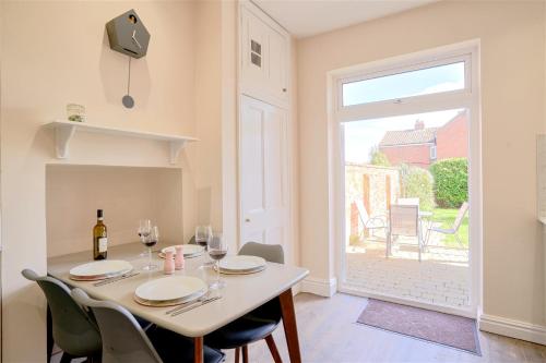 a dining room with a table and chairs and a window at Stunning ground floor apartment near Southwold in Southwold