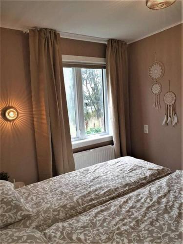 a bedroom with a bed and a window at Greenhouse Golden Circle Villa in Reykholt