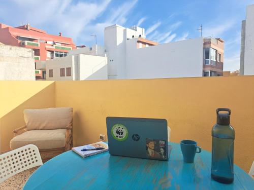 a laptop sitting on a table with a bottle at Daydream Medano Coliving in El Médano
