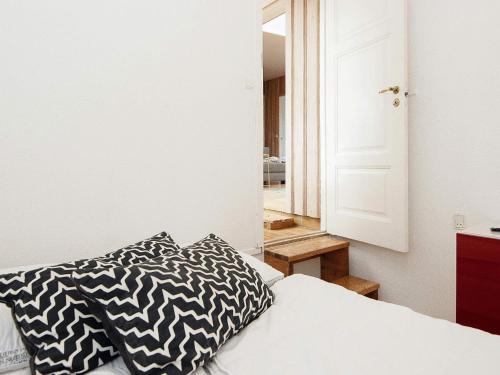 a bedroom with a bed with a black and white pillow at Holiday home Egå III in Egå