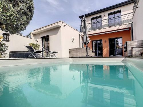 a swimming pool in front of a house at Oasis urbaine à LYON - jardin& jacuzzi in Lyon