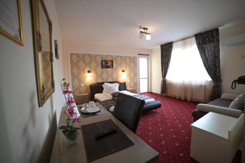 une chambre d'hôtel avec un canapé et un salon dans l'établissement Hotel-Restaurant Oscar, à Piatra Neamţ