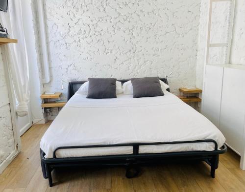 1 cama con 2 almohadas en una habitación en Studio équipé-climatisé avec balcon au Mourillon à 20m de la plage en Toulon