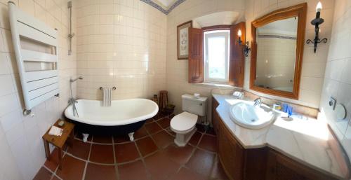 uma casa de banho com uma banheira, um lavatório e um WC. em Casal Serrano Charme e Tranquilidade em Reguengo Grande