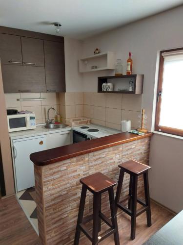 eine Küche mit einer Theke und 2 Hockern in der Unterkunft Kuca za odmor Drina & Tara in Bajina Bašta