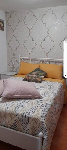 ein Schlafzimmer mit einem Bett mit orangefarbenen und grauen Kissen in der Unterkunft Un rincon en barraña in Boiro