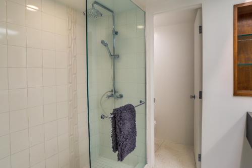 - Baño con ducha de cristal y toalla en Palm Springs Condo with 2 Community Heated Pools!, en Palm Springs