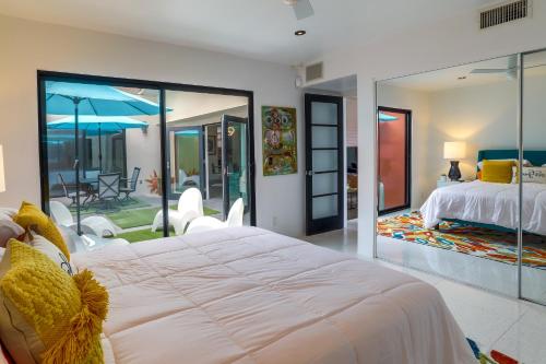 1 dormitorio con 1 cama blanca grande y un espejo grande en Palm Springs Condo with 2 Community Heated Pools!, en Palm Springs