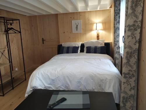 a bedroom with a bed with a remote control on it at Les gîtes d'Alex n°2 in Quend