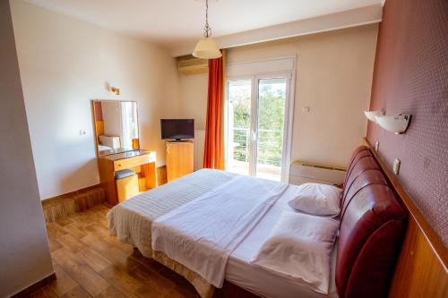 a hotel room with a bed and a window at Giannis Hotel in Kimméria
