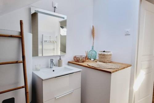une salle de bain blanche avec un lavabo et un miroir dans l'établissement *Le Duplex de Ronsard*Plage et Centre-Ville, à Dunkerque