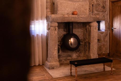 a bench in a room with a stone wall at Quinta de São Francisco Houses in Viseu