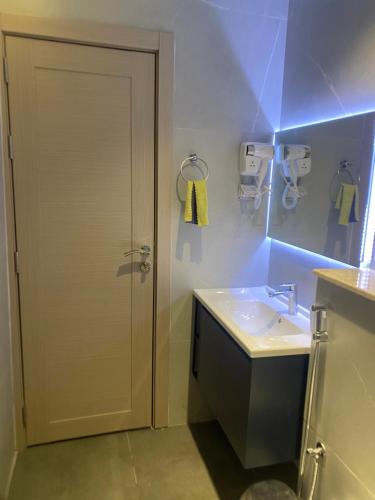 ein Badezimmer mit einem Waschbecken und einer weißen Tür in der Unterkunft Wadishab balcony in Ash Shāb
