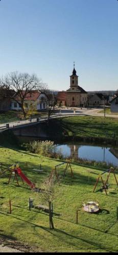 a park with a playground and a pond and a building at Kuća za odmor BIĐ in Šiškovci