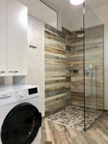a bathroom with a shower and a washing machine at Garsonieră- Bulevard Dem Rădulescu in Râmnicu Vâlcea