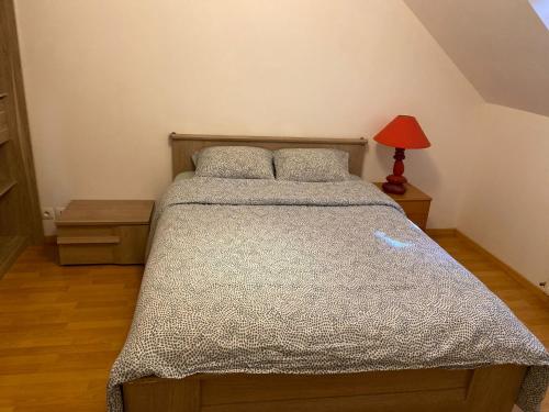 a bedroom with a bed and a red lamp at Location de vacances avec terrasse pour 6 pers, à 2 mn des plages, centre ville et commodités in Douarnenez