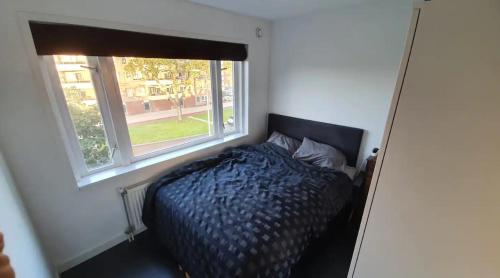 1 dormitorio con cama y ventana en Luminous appartment - Juliana Park free parking, en Utrecht