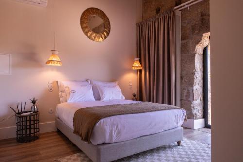 a bedroom with a bed and a mirror on the wall at Quinta de São Francisco Houses in Viseu