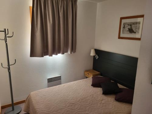 une chambre avec un lit et une fenêtre dans l'établissement Appartement haute Alpes, à Saint-Étienne-en-Dévoluy