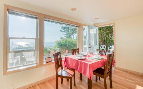 a dining room with a table and chairs and a large window at Agate Beach Oceanfront Suite B in Newport