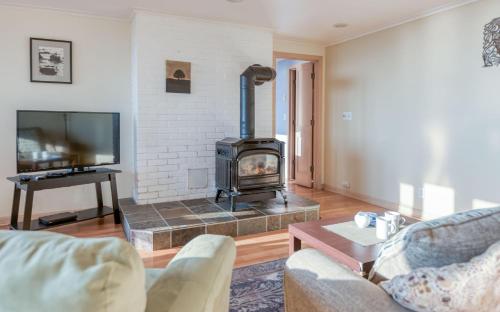 a living room with a fireplace and a tv at Agate Beach Oceanfront Suite B in Newport