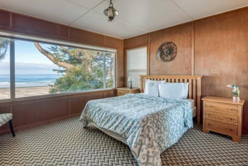 a bedroom with a bed with a view of the beach at Agate Beach Oceanfront Lodge in Newport