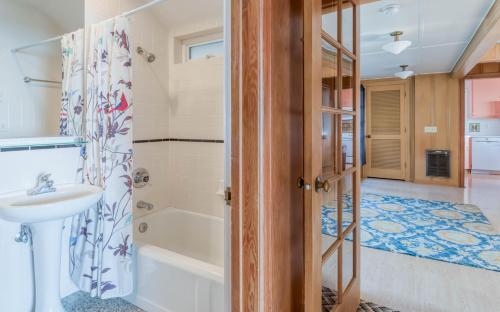 a bathroom with a tub and a sink and a shower at Agate Beach Oceanfront Lodge in Newport