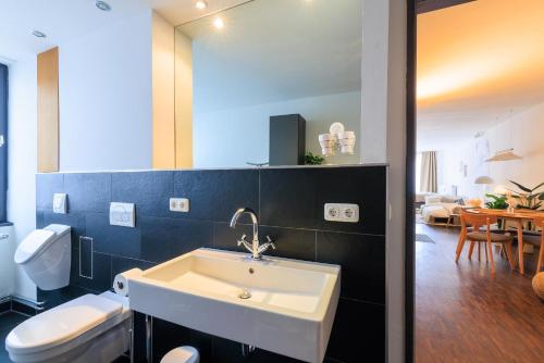 y baño con lavabo y aseo. en Global Living - Design Apartment I City Center I Beamer I Kitchen I Augsburg, en Augsburg