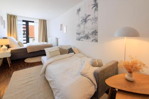 Sala de estar con cama y mesa en Global Living - Design Apartment I City Center I Beamer I Kitchen I Augsburg, en Augsburg