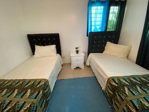 a bedroom with two beds and a night stand at Santiago City Center Huge nice Apartment to stay rooftop to enjoy the city view in Santiago de los Caballeros