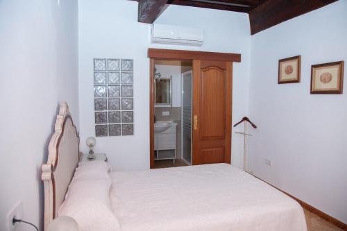 1 dormitorio con 1 cama y puerta de madera en Claustro de las Clarisas en Villanueva de los Infantes