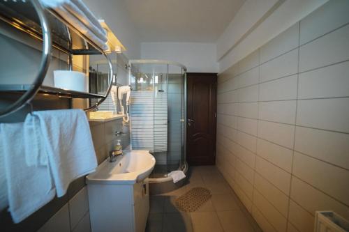 a bathroom with a sink and a shower at Hotel-Restaurant Oscar in Piatra Neamţ