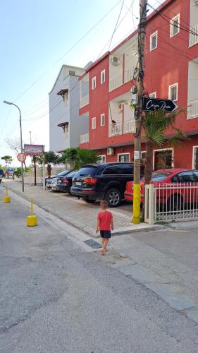 Młody chłopiec spacerujący ulicą w pobliżu budynku w obiekcie ALBERTI w mieście Shëngjin