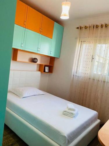 um quarto com uma cama com armários azuis e uma janela em Cosy Apartment Tirana em Tirana
