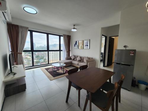 a living room with a table and a couch at Executive Premium Urban Suites - Jelutong in Jelutong
