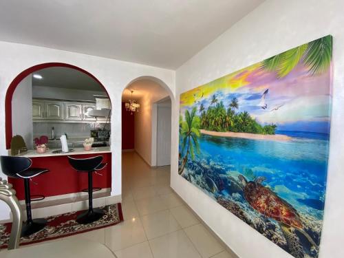 a kitchen with a large painting on the wall at Santiago City Center Huge nice Apartment to stay rooftop to enjoy the city view in Santiago de los Caballeros