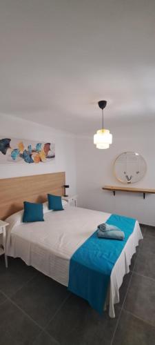 een slaapkamer met een groot bed met blauwe kussens bij Casa jablillo 2 in Costa Teguise