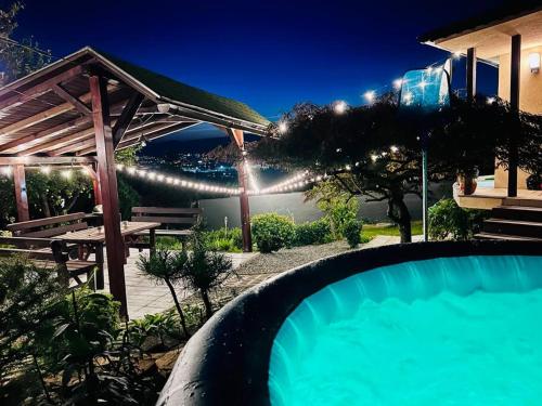 a swimming pool in front of a house at night at Útulný malý domček s vírivkou in Košice
