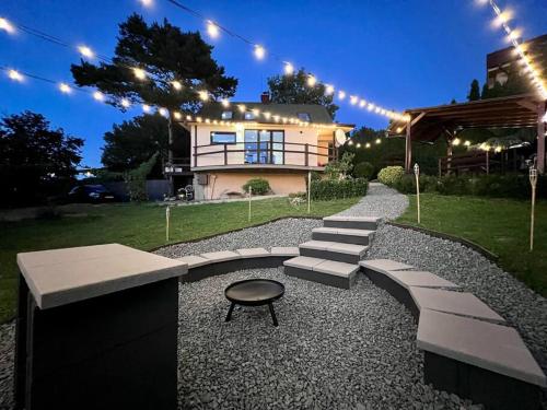a backyard with a house and a bench and lights at Útulný malý domček s vírivkou in Košice