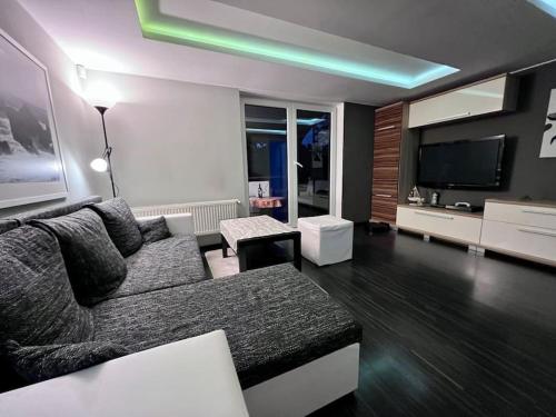 a living room with a couch and a flat screen tv at Útulný malý domček s vírivkou in Košice